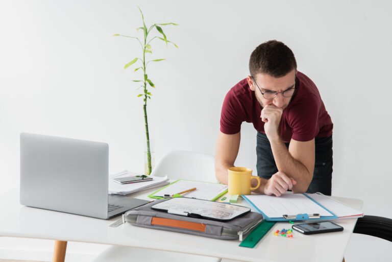 man-leaning-his-desk-being-focused